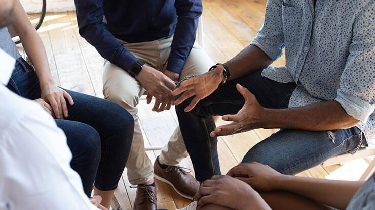 Closeup of lower bodies of a group of people in a counseling circle