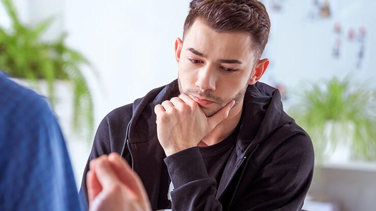 Male student listening with counselor